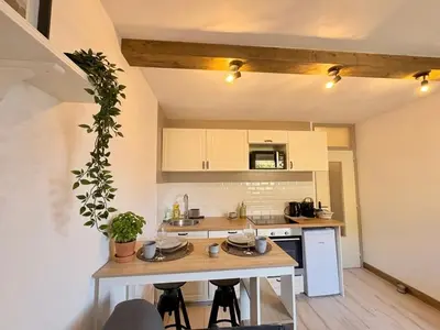 a living room with a kitchen with a table at Charmant appartement à Saint-Gervais-les-Bains, idéal pour vos vacances à la montagne in Saint-Gervais-les-Bains