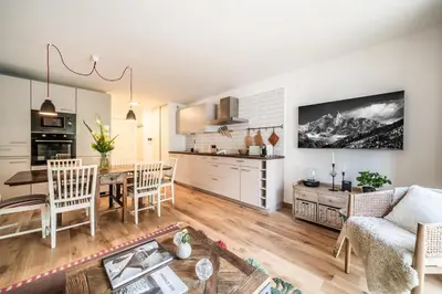 a kitchen and living room with a table and chairs at Apartment Cumaru, Les Houches - by EMERALD STAY in Les Houches