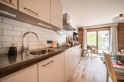 a kitchen with white cabinets and a sink at Apartment Cumaru, Les Houches - by EMERALD STAY in Les Houches