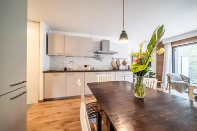 a kitchen with a wooden table with a vase of flowers at Apartment Cumaru, Les Houches - by EMERALD STAY in Les Houches