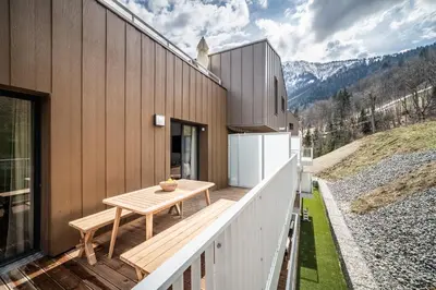 a wooden deck with a table on the side of a house at Apartment Cumaru, Les Houches - by EMERALD STAY in Les Houches