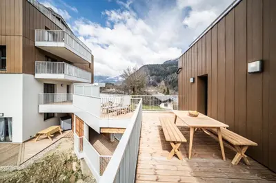 a balcony with a wooden table on a building at Apartment Cumaru, Les Houches - by EMERALD STAY in Les Houches