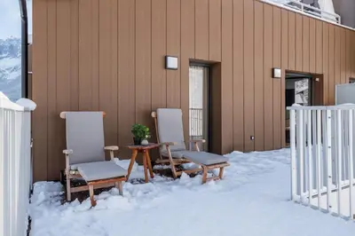 a table and chairs in the snow next to a building at Apartment Cumaru, Les Houches - by EMERALD STAY in Les Houches