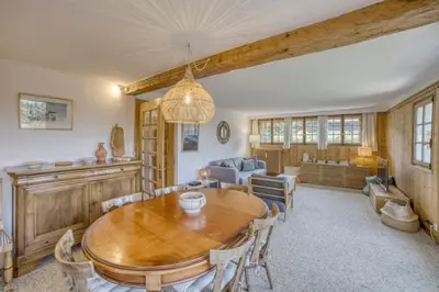 a dining room with a wooden table and chairs at Megève 4 seasons apartment in Megève