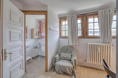 a living room with a chair and a window at Megève 4 seasons apartment in Megève