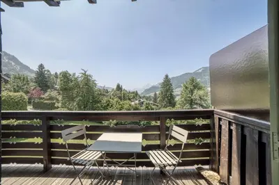 a couple of chairs sitting on a deck with a view at Megève 4 seasons apartment in Megève