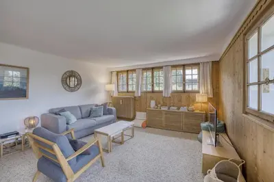 a living room with a couch and a table at Megève 4 seasons apartment in Megève