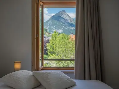 a bedroom with a window with a view of a mountain at TigerLily, Samoens in Samoëns