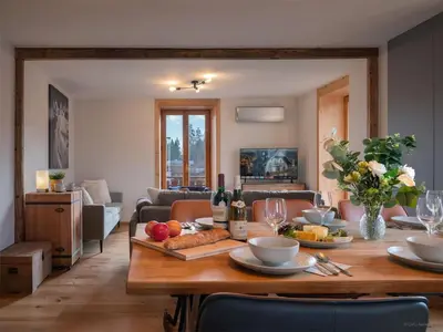 a living room with a table with food and wine bottles at TigerLily, Samoens in Samoëns