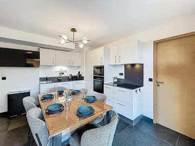 a kitchen with a wooden table and chairs in a room at Appartement neuf 2 chambres près des pistes à Combloux avec parking - FR-1-560-158 in Combloux