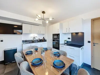 a dining room with a wooden table and chairs at Appartement neuf 2 chambres près des pistes à Combloux avec parking - FR-1-560-158 in Combloux