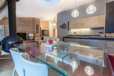a dining room with a glass table and white chairs at Elegant 3 Bedroom Apartment, Central Chamonix in Chamonix-Mont-Blanc