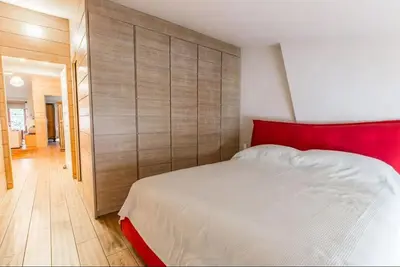 a bedroom with a white bed and a red headboard at Elegant 3 Bedroom Apartment, Central Chamonix in Chamonix-Mont-Blanc