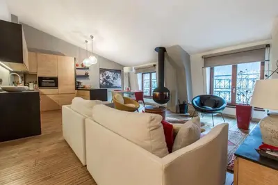 a living room with a white couch and a kitchen at Elegant 3 Bedroom Apartment, Central Chamonix in Chamonix-Mont-Blanc