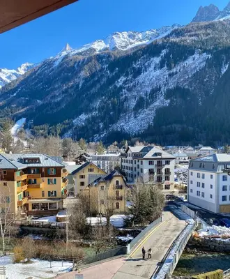 a city with buildings and mountains in the background at Elegant 3 Bedroom Apartment, Central Chamonix in Chamonix-Mont-Blanc