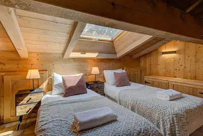 two beds in a room with wooden walls at Apartment Soleil, Alpes Travel, Argentière, Sleeps 9 in Chamonix-Mont-Blanc