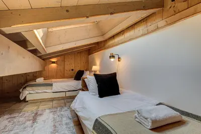 two beds in a room with wooden ceilings at Apartment Soleil, Alpes Travel, Argentière, Sleeps 9 in Chamonix-Mont-Blanc