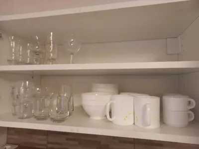 a shelf with glasses and other glass items on it at Au pied des pistes in Les Contamines-Montjoie