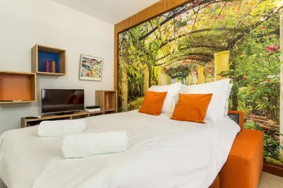 a bedroom with a large white bed with orange pillows at Apartment Maisonnee - A Charming Chamonix Haven in Chamonix-Mont-Blanc