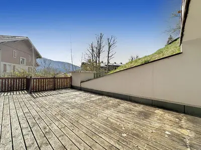 a wooden deck with a fence and a house at ROUS02 Appartement 6 8 personnes au centre station in Les Carroz d'Araches