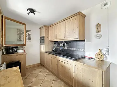 a kitchen with wooden cabinets and a sink at ROUS02 Appartement 6 8 personnes au centre station in Les Carroz d'Araches