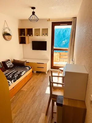 a room with a bed and a desk with a window at Samoëns 1600 au pied des pistes in Samoëns