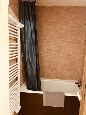 a bathroom with a shower curtain and a bath tub at Samoëns 1600 au pied des pistes in Samoëns