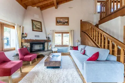 a living room with a blue couch and red chairs at Chalet Sapi in Combloux