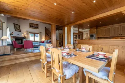 a kitchen and dining room with a wooden table and chairs at Chalet Sapi in Combloux