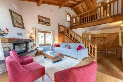 a living room with a couch and chairs and a fireplace at Chalet Sapi in Combloux