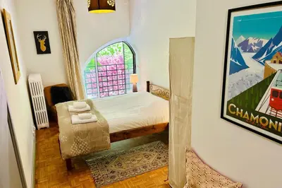 a small bedroom with a bed and a window at Magnificent duplex in a former Palace in Chamonix-Mont-Blanc