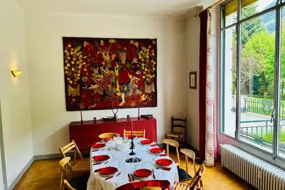 a dining room with a table and a painting on the wall at Magnificent duplex in a former Palace in Chamonix-Mont-Blanc