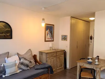 a living room with a couch and a table at Le studio du Cerf in Chamonix-Mont-Blanc