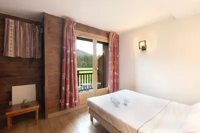 a bedroom with a bed and a window at Cabana & Alp'évasion - Pools, Sauna, Pool Table in Samoëns