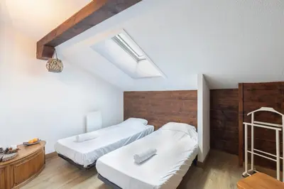 a bedroom with two beds and a wooden wall at Cabana & Alp'évasion - Pools, Sauna, Pool Table in Samoëns