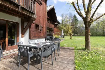 a wooden deck with a table and chairs at Cabana & Alp'évasion - Pools, Sauna, Pool Table in Samoëns