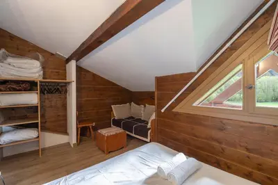 a attic room with a bed and a window at Cabana & Alp'évasion - Pools, Sauna, Pool Table in Samoëns