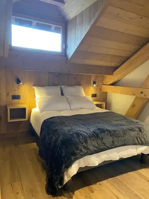 a bedroom with a large bed in a attic at Les Séracs in Combloux