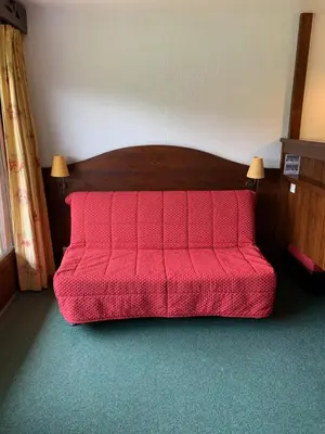 a red bed in a room with a red comforter at Mont arbois megeve in Megève