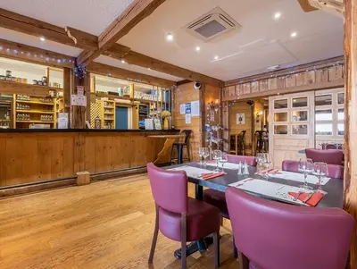 a dining room with a long table and purple chairs at Mont arbois megeve in Megève