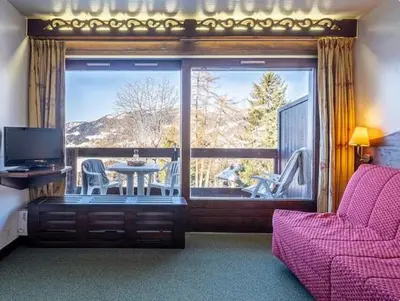 a living room with a balcony with a table and chairs at Mont arbois megeve in Megève