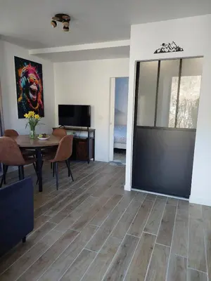 a living room with a dining room table and a sliding glass door at Appartement adapté PMR 4 personnes Saint Gervais les Bains in Saint-Gervais-les-Bains