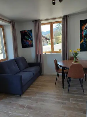 a living room with a blue couch and a table at Appartement adapté PMR 4 personnes Saint Gervais les Bains in Saint-Gervais-les-Bains