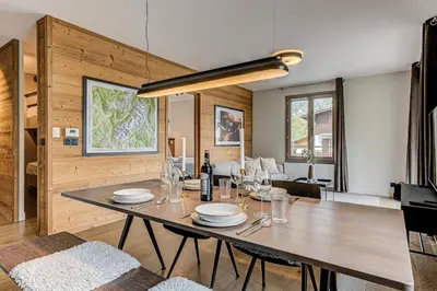 a dining room and living room with a table and chairs at White Pearl Mountains Modern 2-bedroom apartment with great location in Chamonix-Mont-Blanc