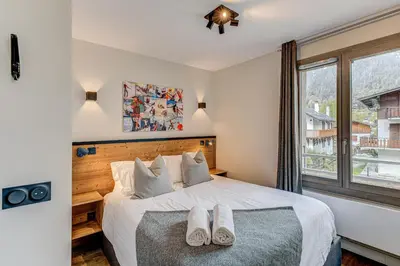 a bedroom with a bed with two pairs of shoes on it at White Pearl Mountains Modern 2-bedroom apartment with great location in Chamonix-Mont-Blanc