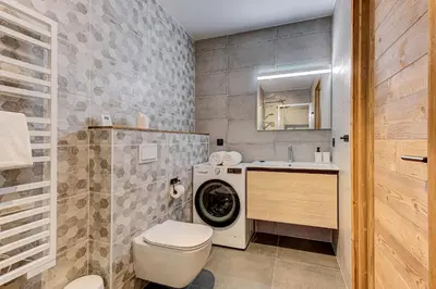 a bathroom with a washing machine and a sink at White Pearl Mountains Modern 2-bedroom apartment with great location in Chamonix-Mont-Blanc