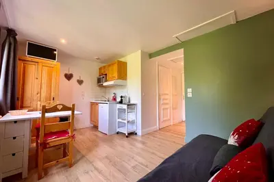 a living room with a couch and a kitchen at Petite Cordée in Combloux