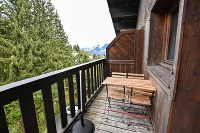 a wooden porch with a bench on a balcony at Petite Cordée in Combloux