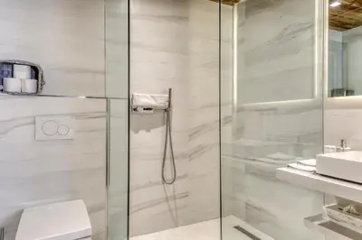 a bathroom with a shower with a toilet and a sink at Chalet de luxe proche du village de Megève in Megève