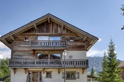 a wooden house with a balcony on top of it at Chalet de luxe proche du village de Megève in Megève